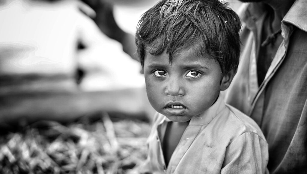 Emotive black and white portrait capturing a South Asian child's expressive gaze.